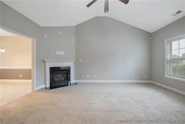 an empty room with windows and fireplace