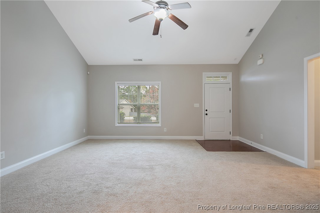 159 English Oak Drive Bunnlevel, NC 28323 - Photo 9 of 48 an empty room with chandelier fan and windows