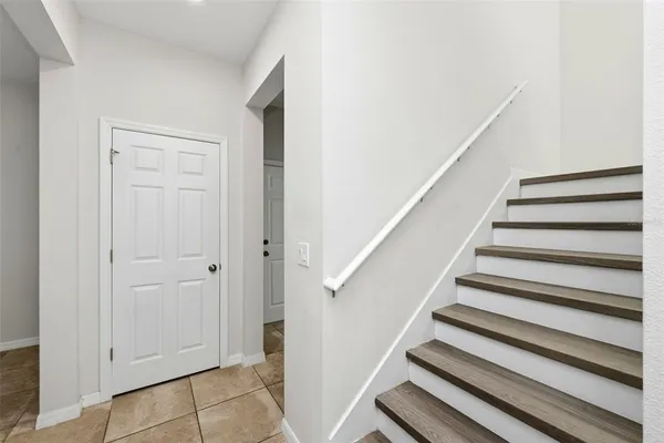 a view of staircase with railing and white walls