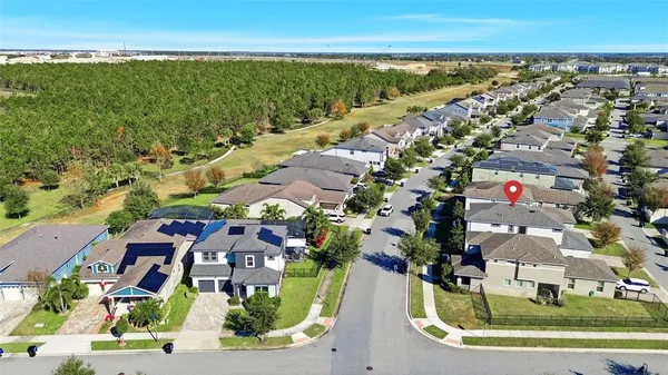 an aerial view of residential houses with outdoor space and ocean view
