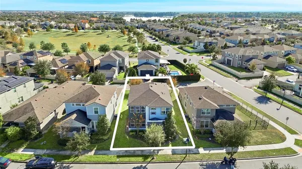 an aerial view of residential houses with outdoor space and ocean view