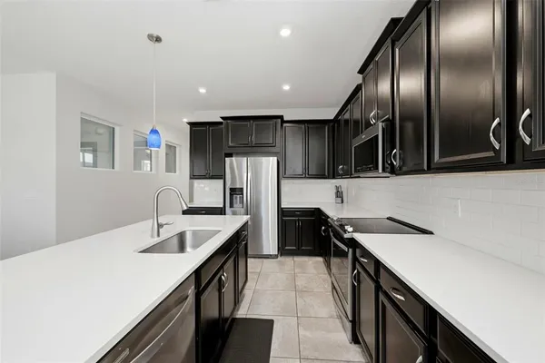 a kitchen with stainless steel appliances granite countertop a sink a stove and a refrigerator