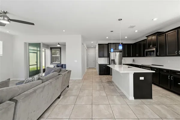 a large kitchen with stainless steel appliances kitchen island granite countertop a large counter top and a stove top oven