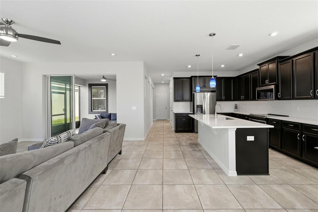 16662 Wingspread Loop Winter Garden, FL 34787 - Photo 8 of 24 a large kitchen with stainless steel appliances kitchen island granite countertop a large counter top and a stove top oven