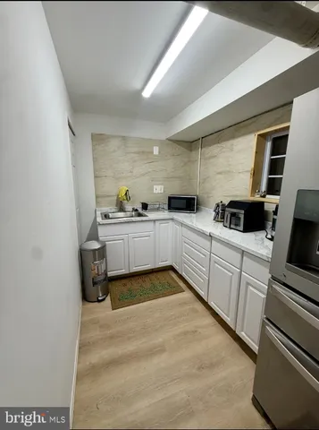 a kitchen with white cabinets and white appliances