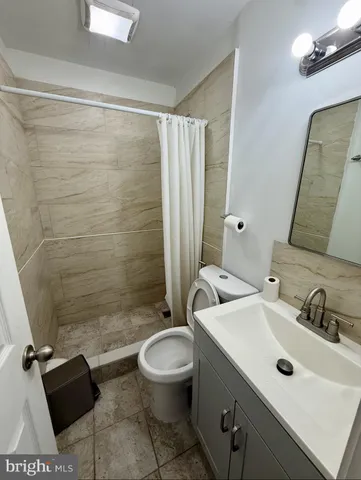 a bathroom with a sink mirror vanity and toilet