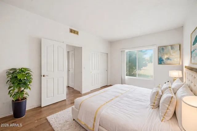 a spacious bedroom with a bed and a potted plant