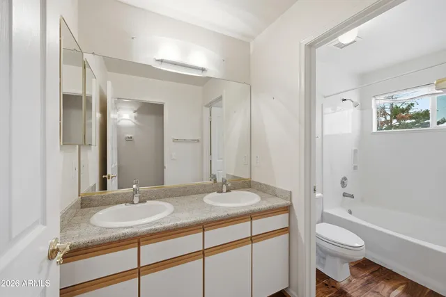a bathroom with a granite countertop sink toilet and a mirror
