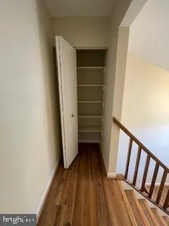 a view of walk in closet with wooden floor