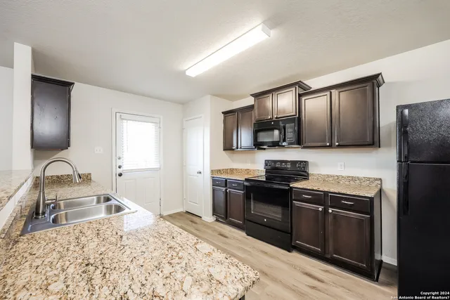 a kitchen with stainless steel appliances granite countertop a refrigerator stove microwave and sink