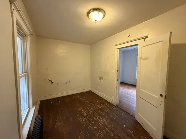 a view of empty room with wooden floor
