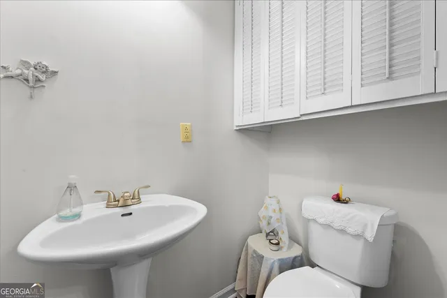 a bathroom with a sink a toilet and mirror