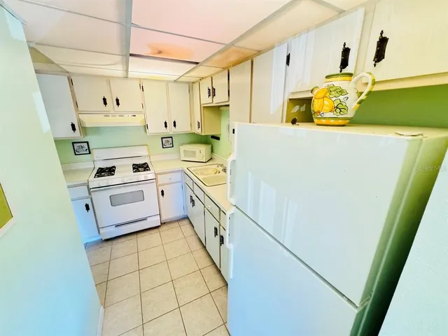 a kitchen with a sink a stove a refrigerator and a window
