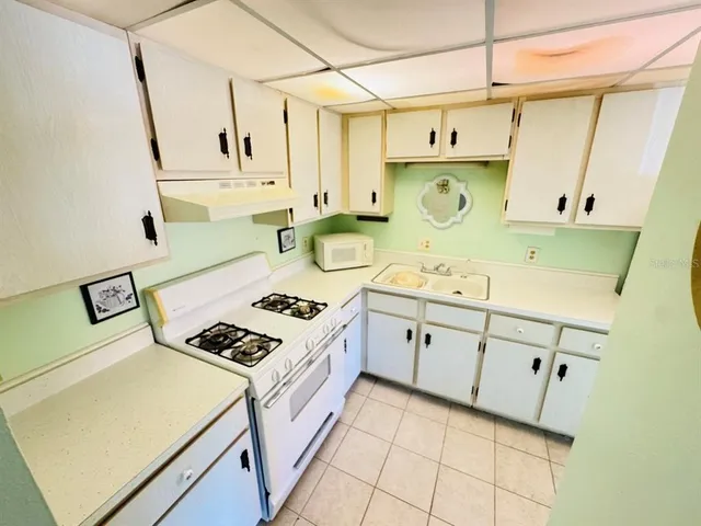 a kitchen with cabinets a stove and a sink