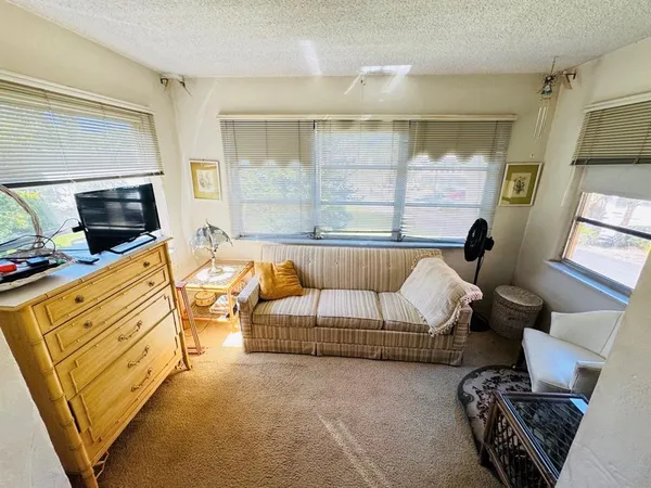 a living room with furniture a flat screen tv and a large window