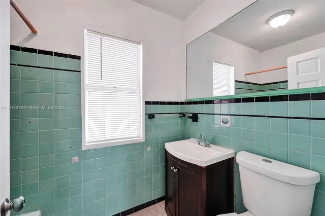 a bathroom with a sink toilet and window