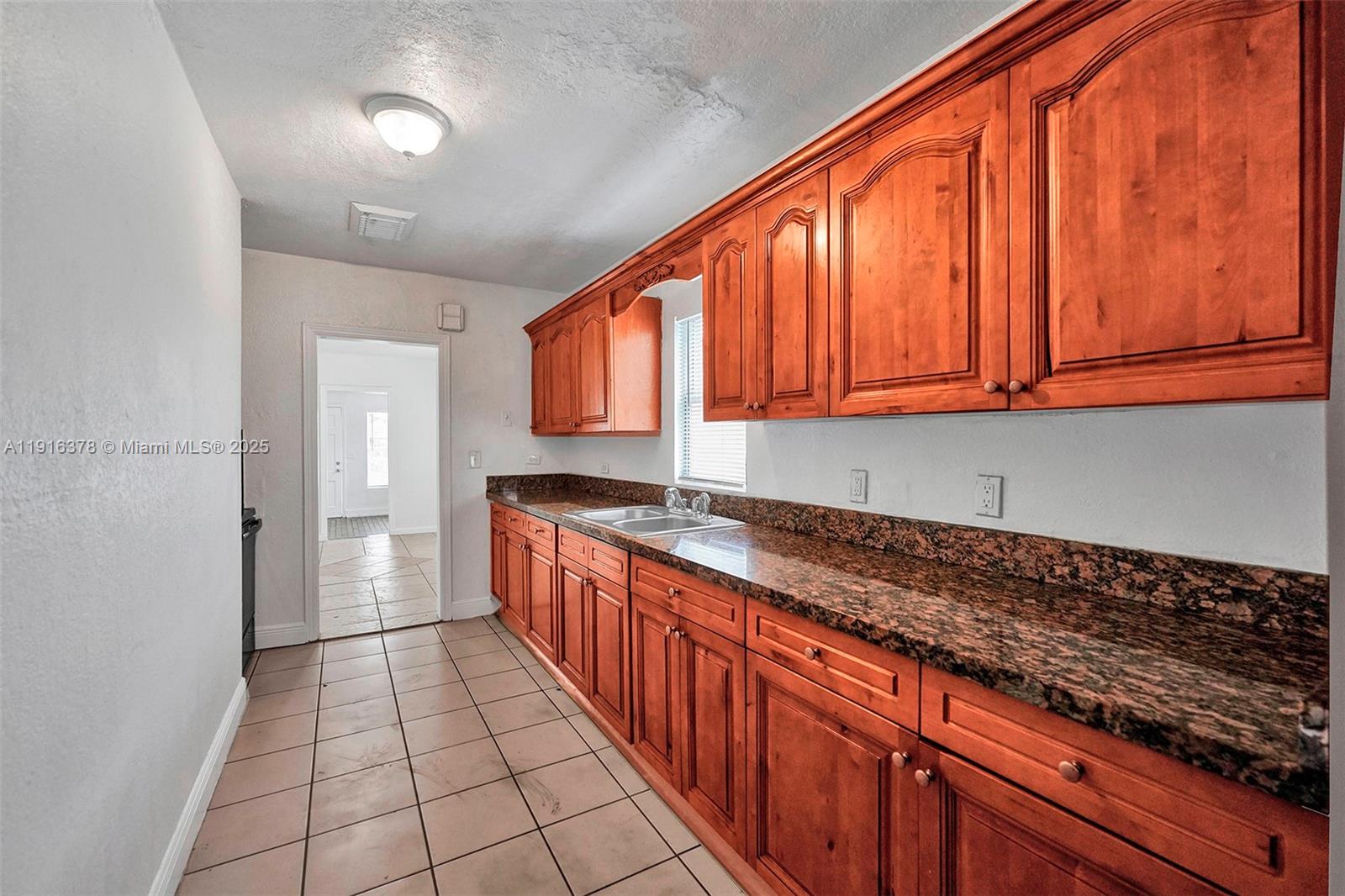 2811 Southwest 3rd Street Miami, FL 33135 - Photo 30 of 40 a kitchen with stainless steel appliances granite countertop a sink and cabinets