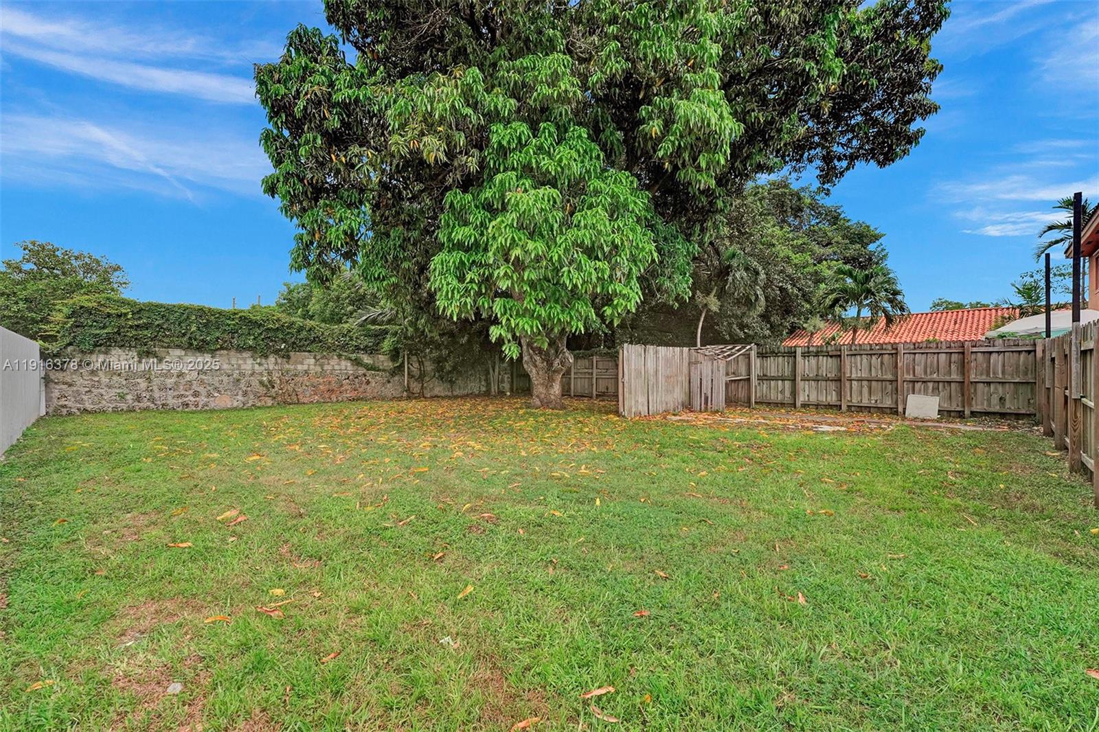 2811 Southwest 3rd Street Miami, FL 33135 - Photo 36 of 40 a view of a yard with a large tree and wooden fence