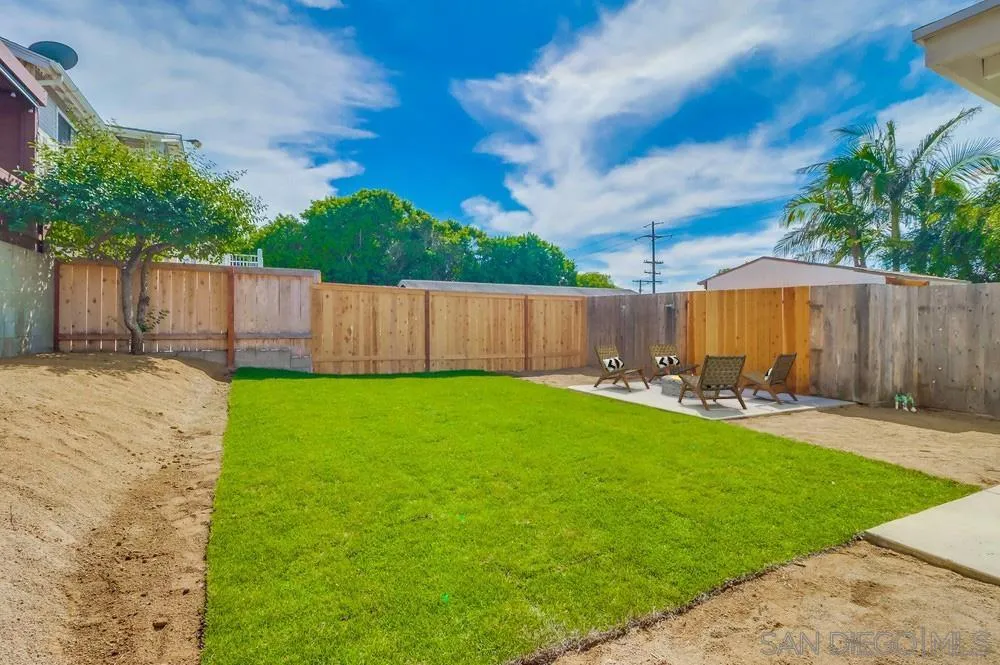 923 Melba Road Encinitas, CA 92024 - Photo 27 of 28 a view of a backyard with table and chairs a barbeque and wooden fence