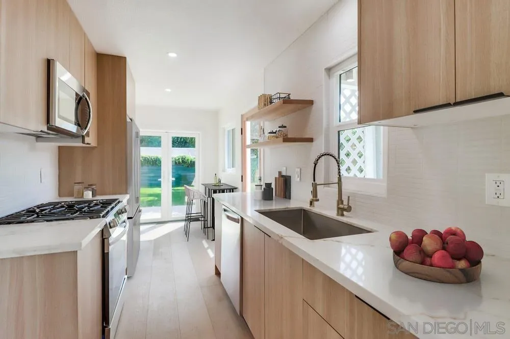 923 Melba Road Encinitas, CA 92024 - Photo 8 of 28 a kitchen with stainless steel appliances a sink a stove and a wooden cabinets