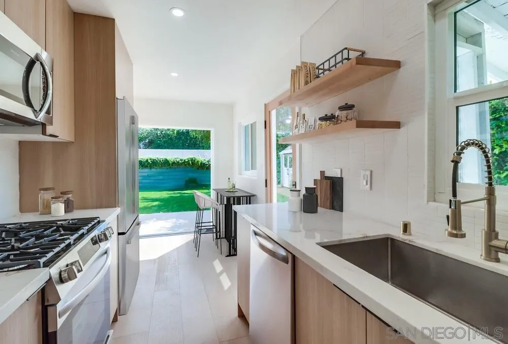 923 Melba Road Encinitas, CA 92024 - Photo 9 of 28 a kitchen with kitchen island granite countertop a sink stove and cabinets