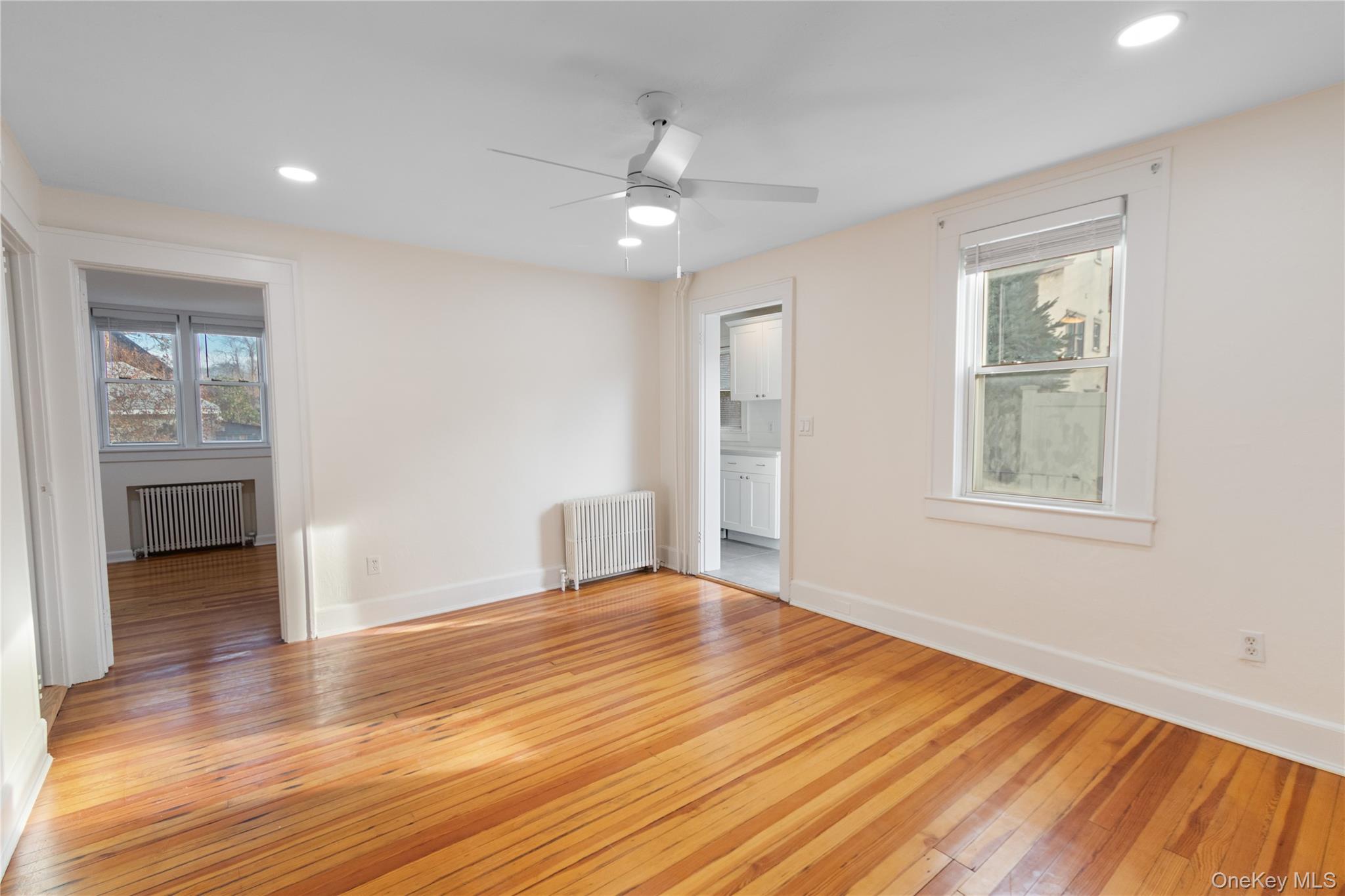 57 Spring Street, Unit 1 Oyster Bay, NY 11771 - Photo 4 of 11 a view of an empty room with wooden floor and a window