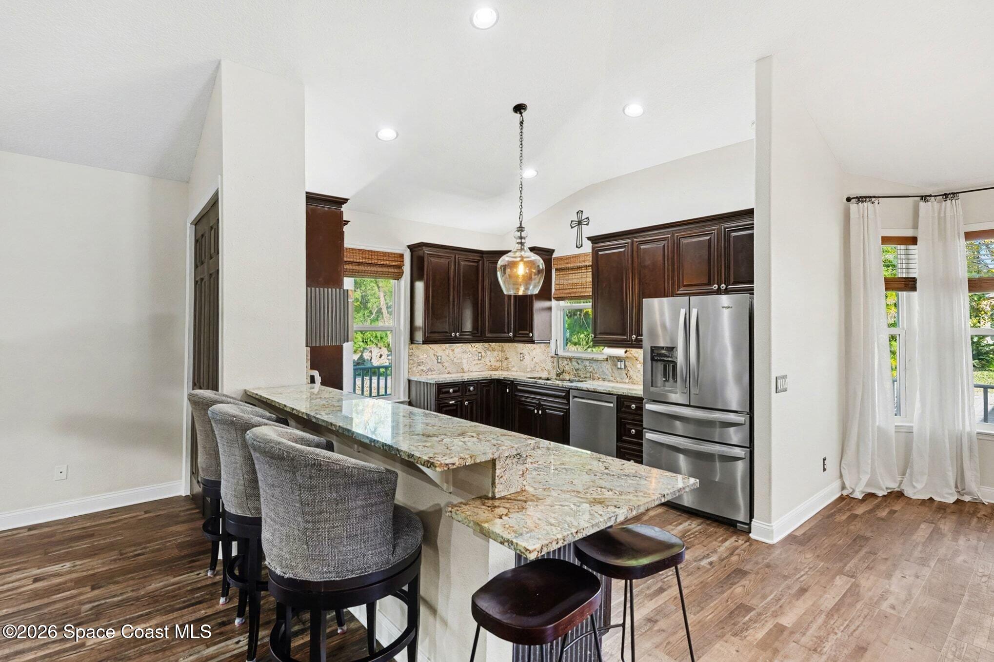 1355 Dalbora Road Merritt Island, FL 32953 - Photo 17 of 37 a kitchen with stainless steel appliances kitchen island granite countertop a refrigerator and a stove top oven
