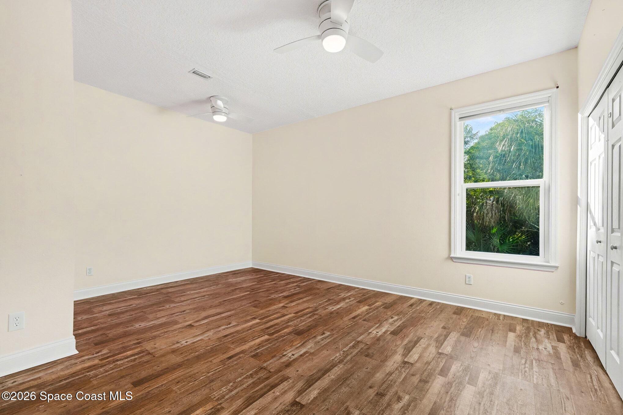 1355 Dalbora Road Merritt Island, FL 32953 - Photo 21 of 37 an empty room with wooden floor and windows