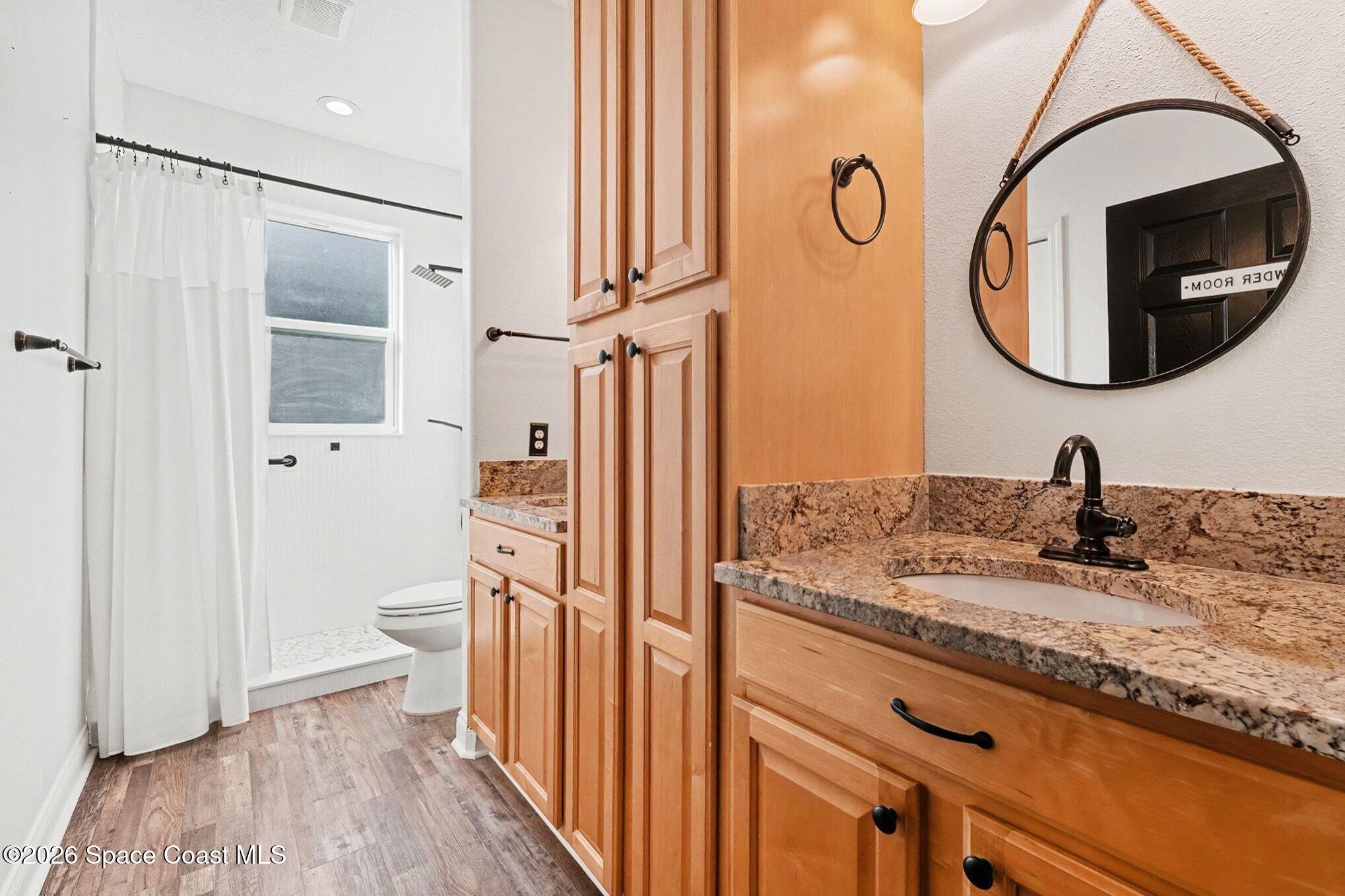 1355 Dalbora Road Merritt Island, FL 32953 - Photo 23 of 37 a bathroom with a granite countertop toilet sink and mirror