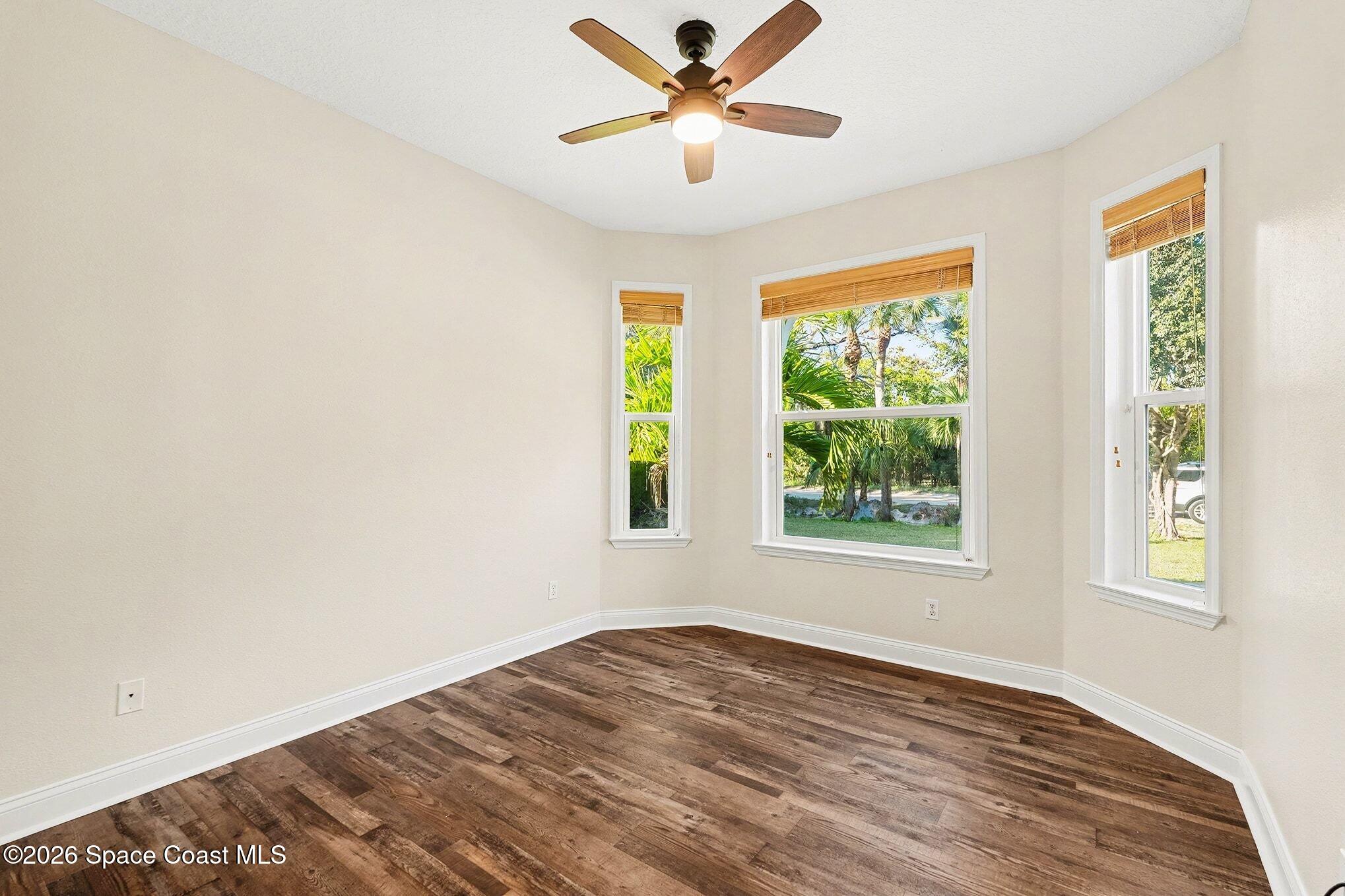 1355 Dalbora Road Merritt Island, FL 32953 - Photo 24 of 37 a view of a bedroom with wooden floor and a ceiling fan