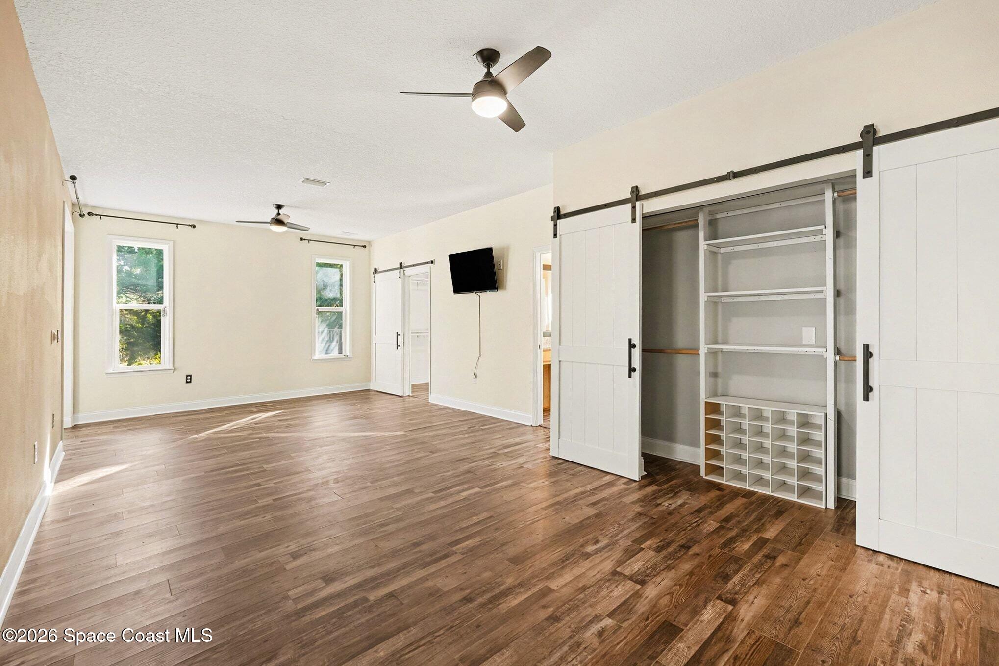 1355 Dalbora Road Merritt Island, FL 32953 - Photo 6 of 37 a view of an empty room with a window and wooden floor
