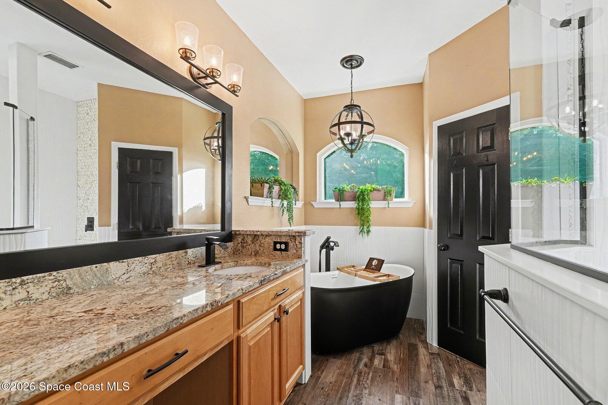 1355 Dalbora Road Merritt Island, FL 32953 - Photo 7 of 37 a spacious bathroom with a bathtub shower sink and mirror