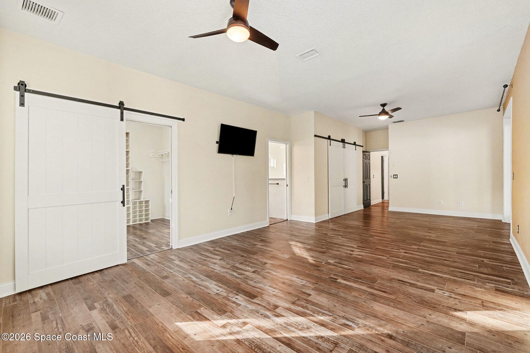 1355 Dalbora Road Merritt Island, FL 32953 - Photo 9 of 37 a view of empty room with wooden floor and ceiling fan
