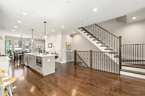 a view of a kitchen with kitchen island wooden floor center island and stainless steel appliances