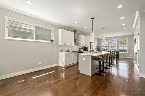 a kitchen with a table chairs refrigerator and cabinets