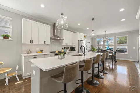 a kitchen with a dining table chairs stainless steel appliances and cabinets