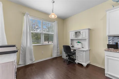 a view of a workspace with furniture and a window