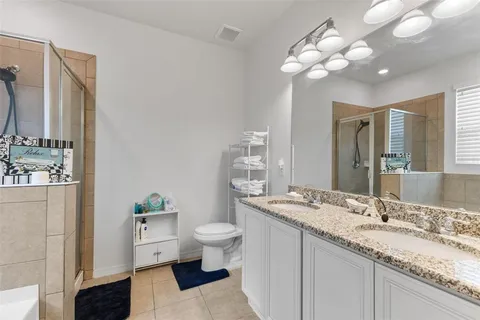 a bathroom with a granite countertop sink mirror and toilet