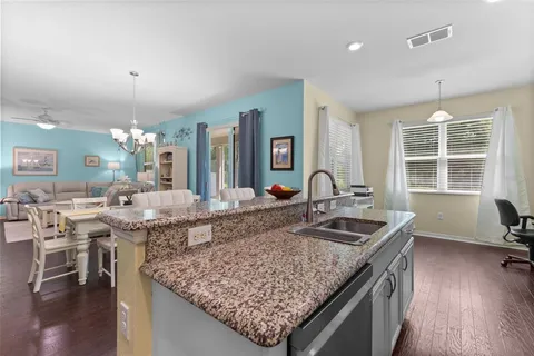 a kitchen with granite countertop kitchen island stainless steel appliances a sink stove and table