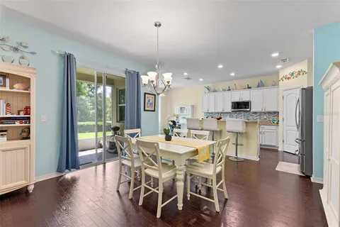 a view of a dining room and livingroom with furniture wooden floor a chandelier
