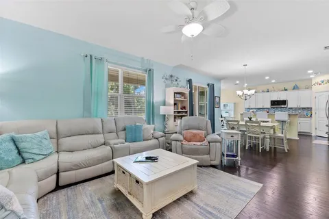 a living room with furniture wooden floor and a large window