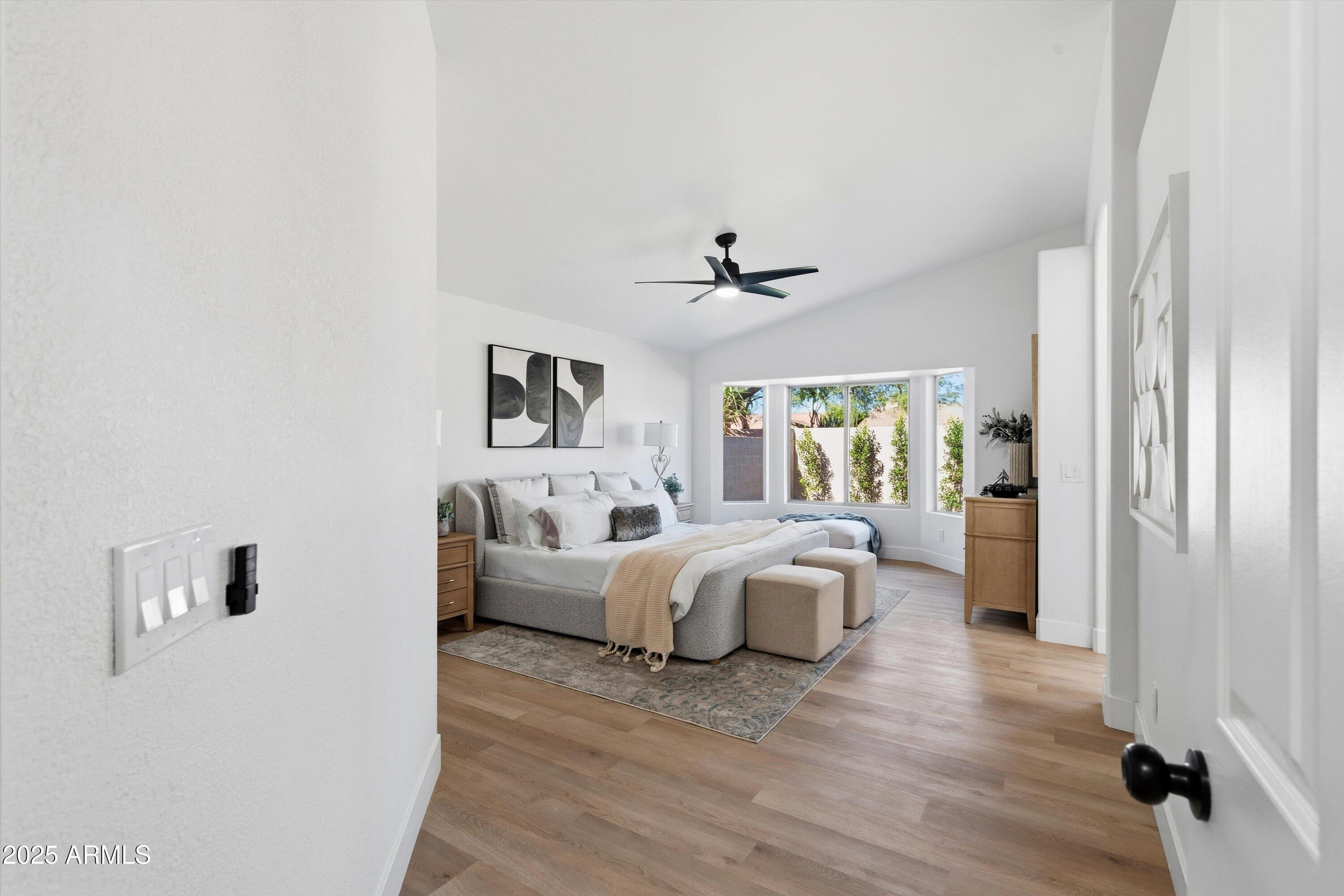4438 East Rowel Road Phoenix, AZ 85050 - Photo 18 of 30 a spacious bedroom with a bed and wooden floor