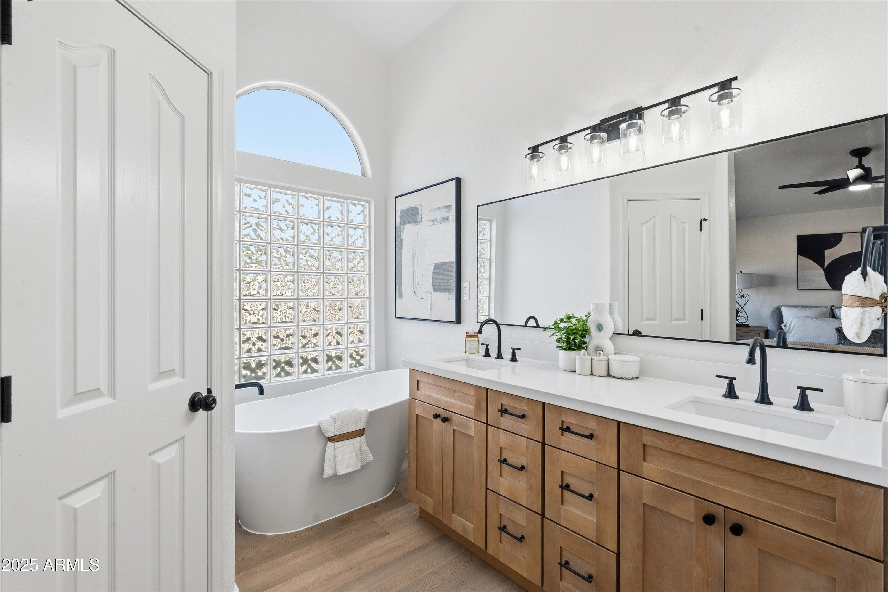 4438 East Rowel Road Phoenix, AZ 85050 - Photo 20 of 30 a spacious bathroom with double vanity a mirror a bathtub and window