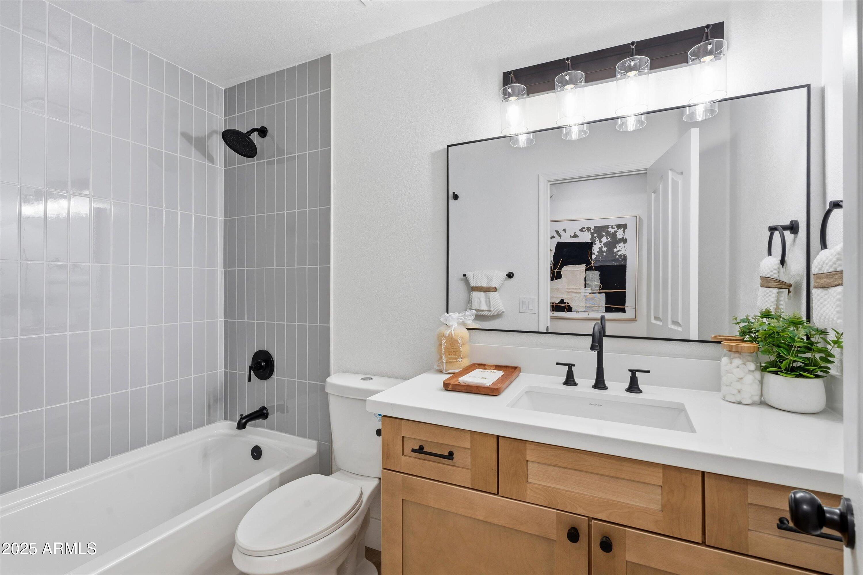 4438 East Rowel Road Phoenix, AZ 85050 - Photo 25 of 30 a bathroom with a sink a large mirror a bathtub and shower