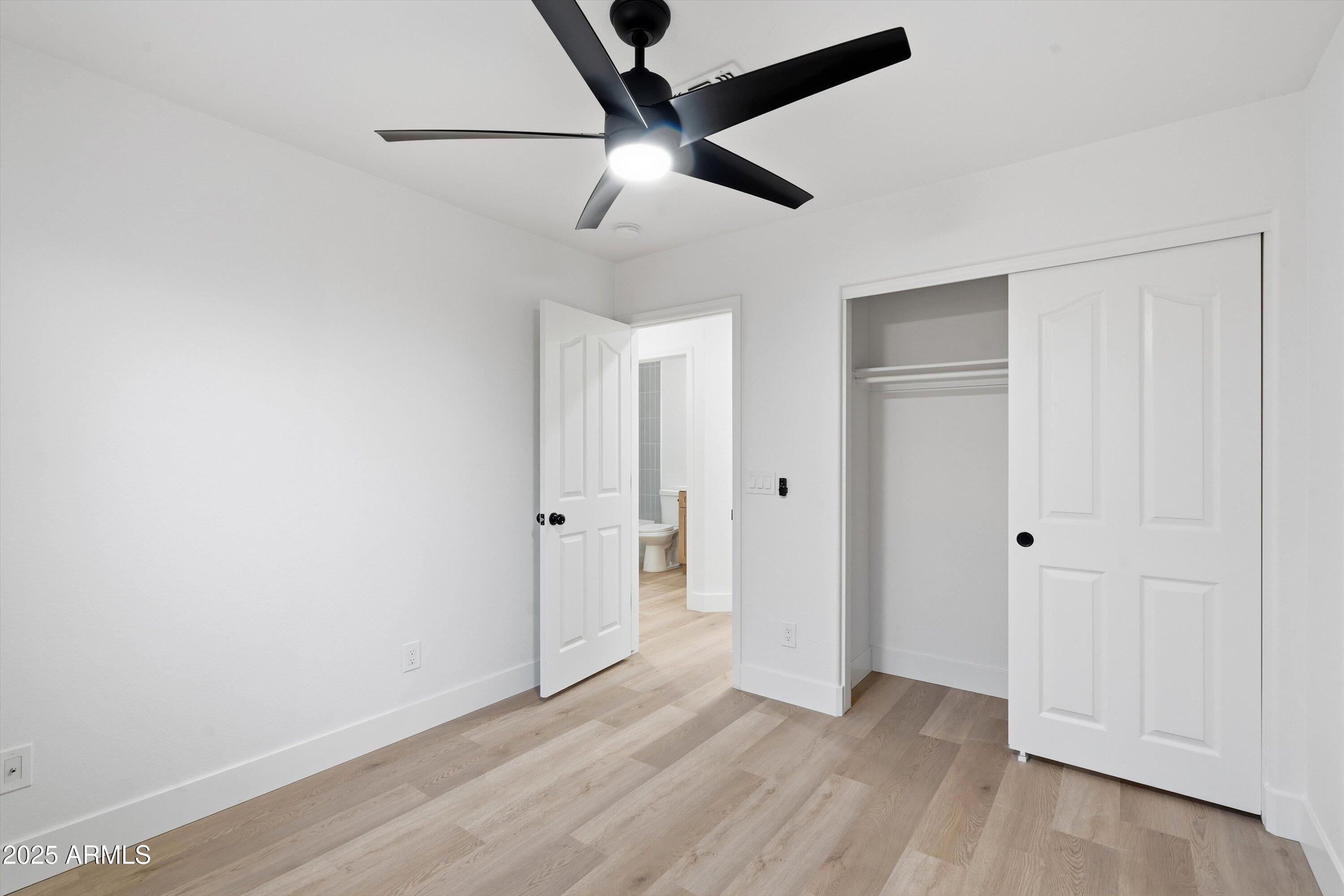 4438 East Rowel Road Phoenix, AZ 85050 - Photo 26 of 30 an empty room with wooden floor ceiling fan and window