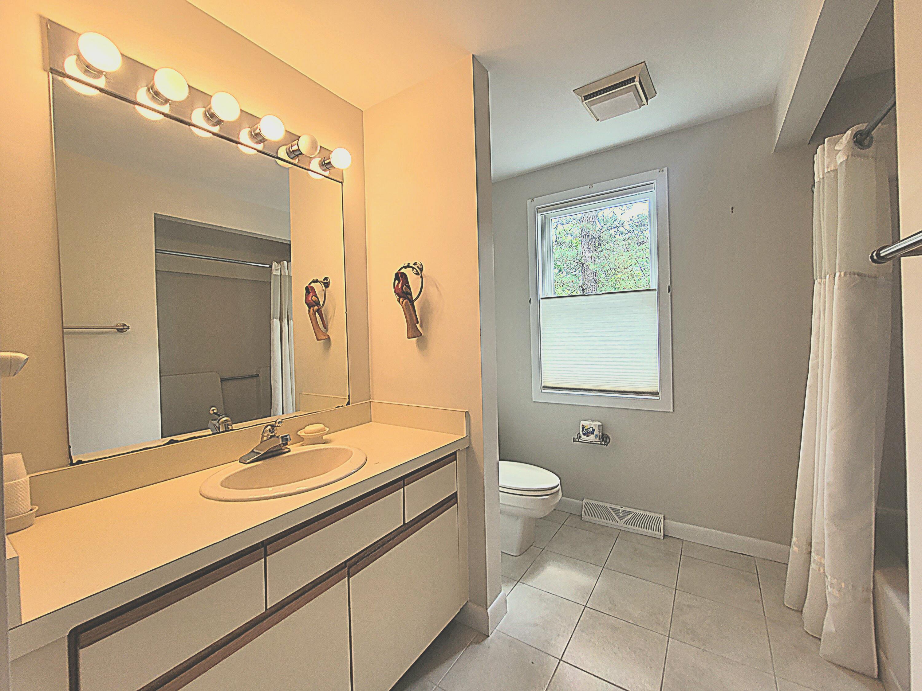 105 Shellback Way, Unit P Mashpee, MA 02649 - Photo 11 of 29 a bathroom with a sink a toilet and mirror