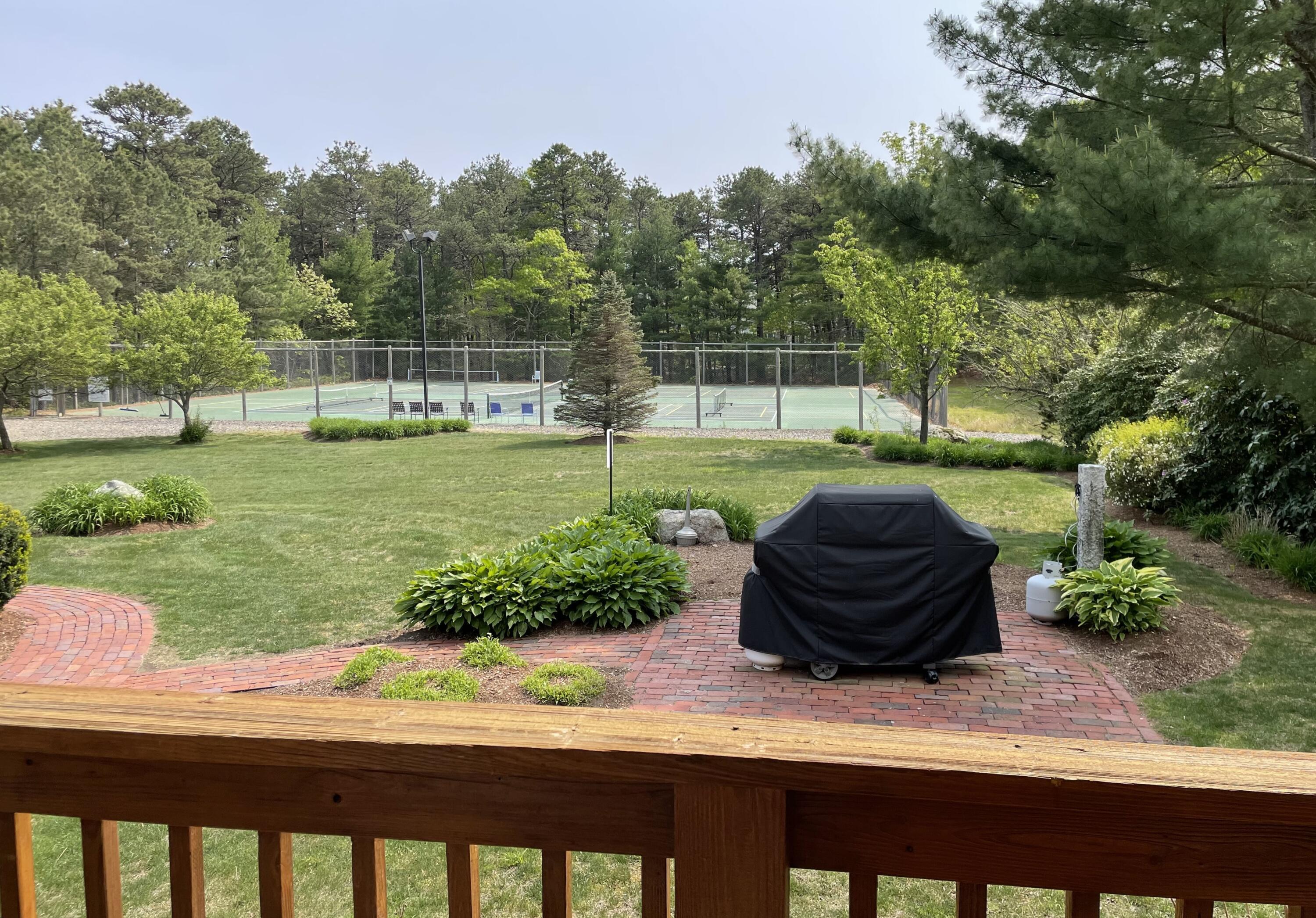 105 Shellback Way, Unit P Mashpee, MA 02649 - Photo 22 of 29 a view of a garden with a chair and fire pit