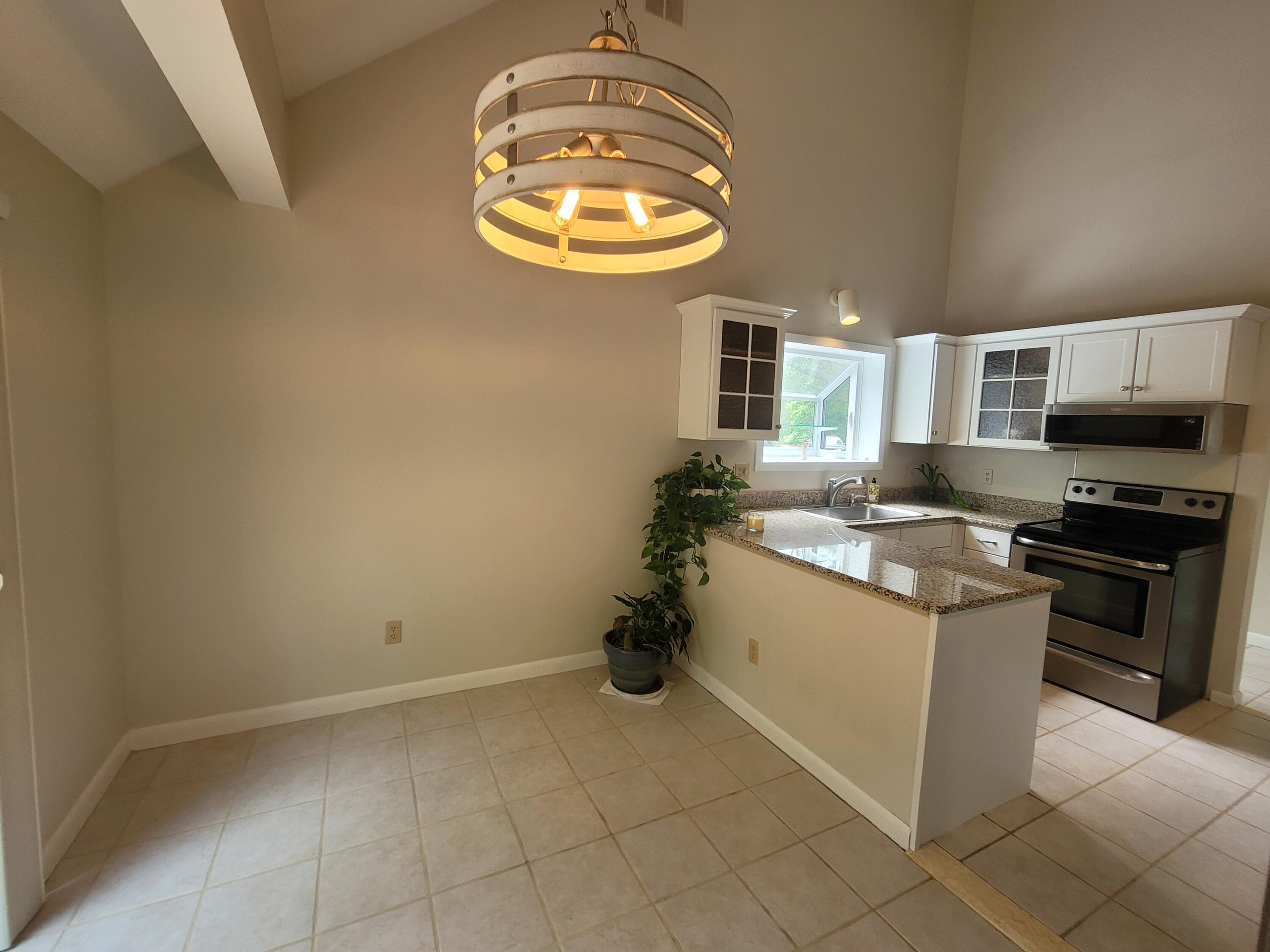 105 Shellback Way, Unit P Mashpee, MA 02649 - Photo 25 of 29 a kitchen with stainless steel appliances granite countertop a sink and a stove