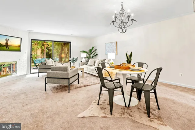 a dining room with furniture a fireplace and a chandelier