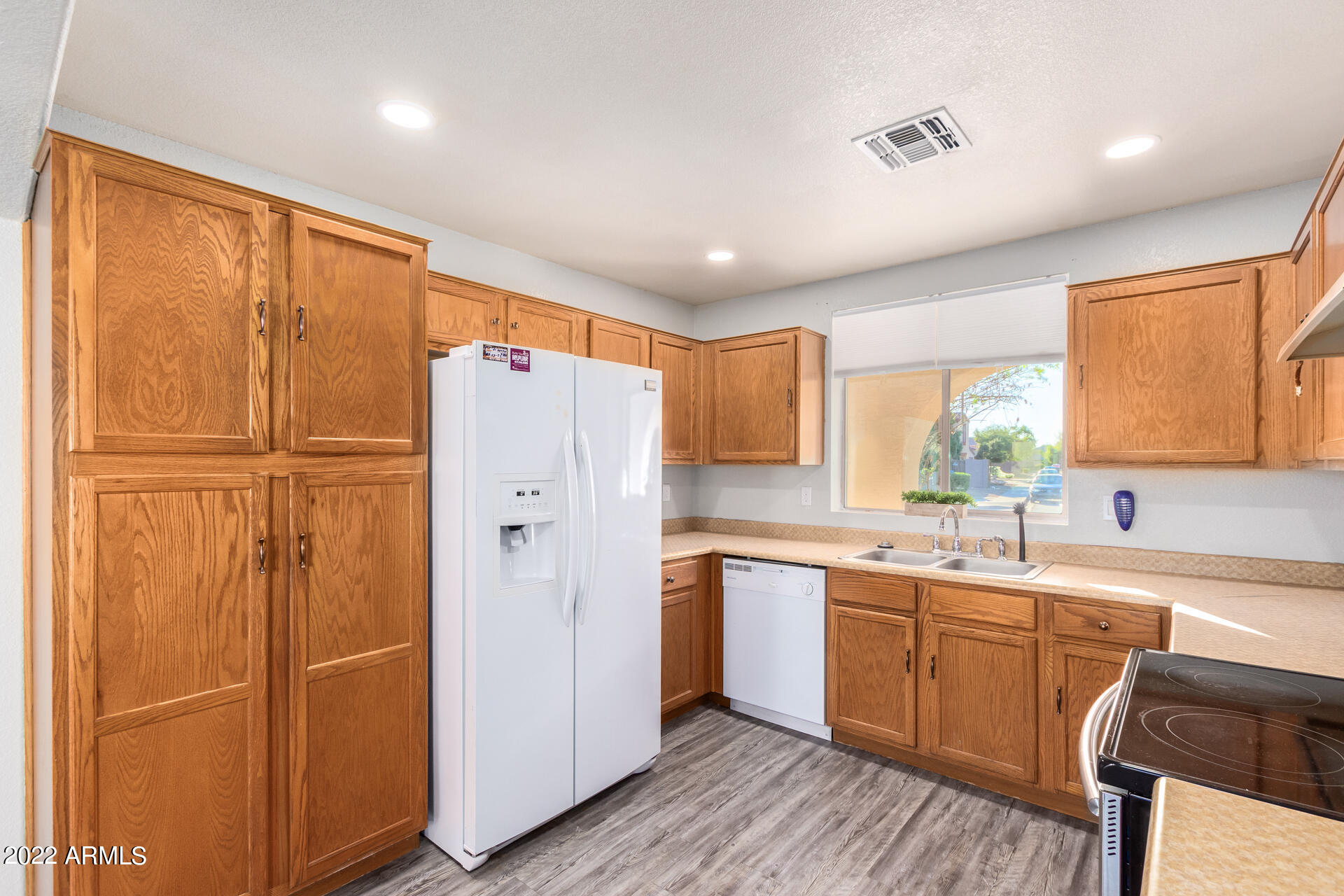 2609 South Devonna Lane Tolleson, AZ 85353 - Photo 11 of 30 a kitchen with a refrigerator a sink and cabinets